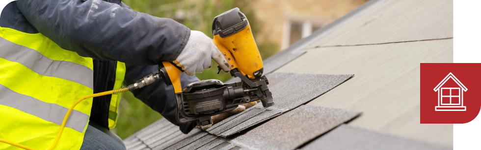 Roofer using nail gun to affix asphalt shingle | Summit Roofing